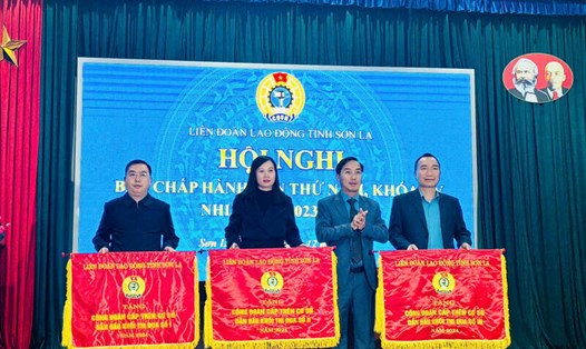 Lãnh đạo LĐLĐ tỉnh Sơn La trao cờ thi đua cho 3 tập thể. Ảnh: Minh Hòa