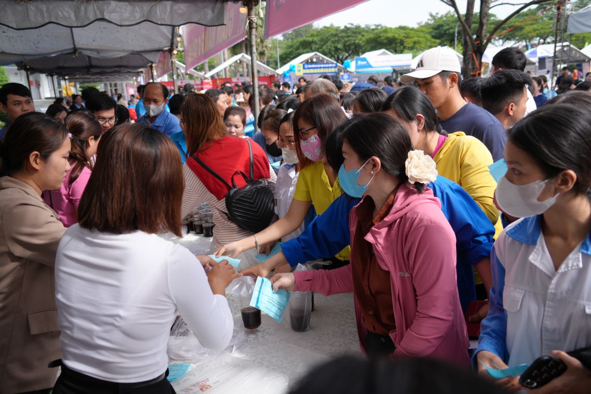 Người lao động dùng phiếu đổi thức ăn, nước uống tại các gian hàng ẩm thực phục vụ miễn phí. Ảnh: Thành An