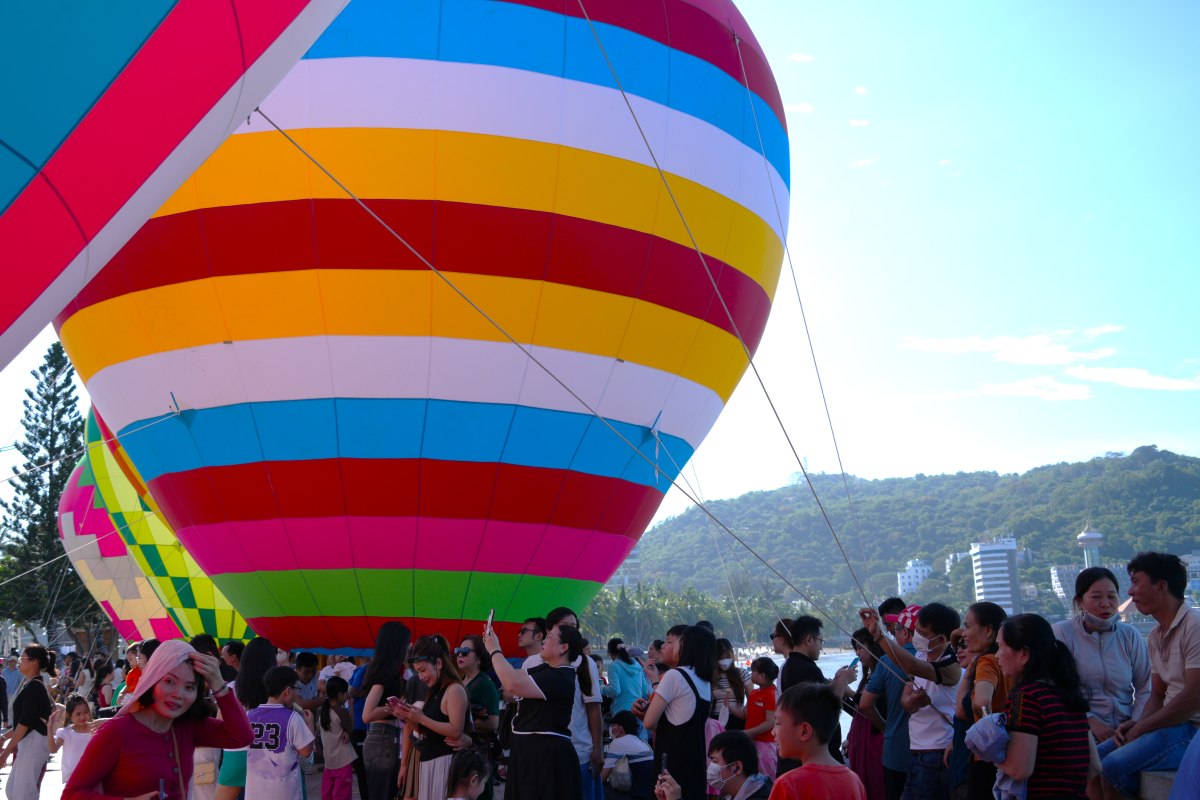 Khá đông người đứng sát mé biển để ngắm khinh khí cầu, tận hưởng không khí mát mẻ ven biển. Ảnh: Thành An