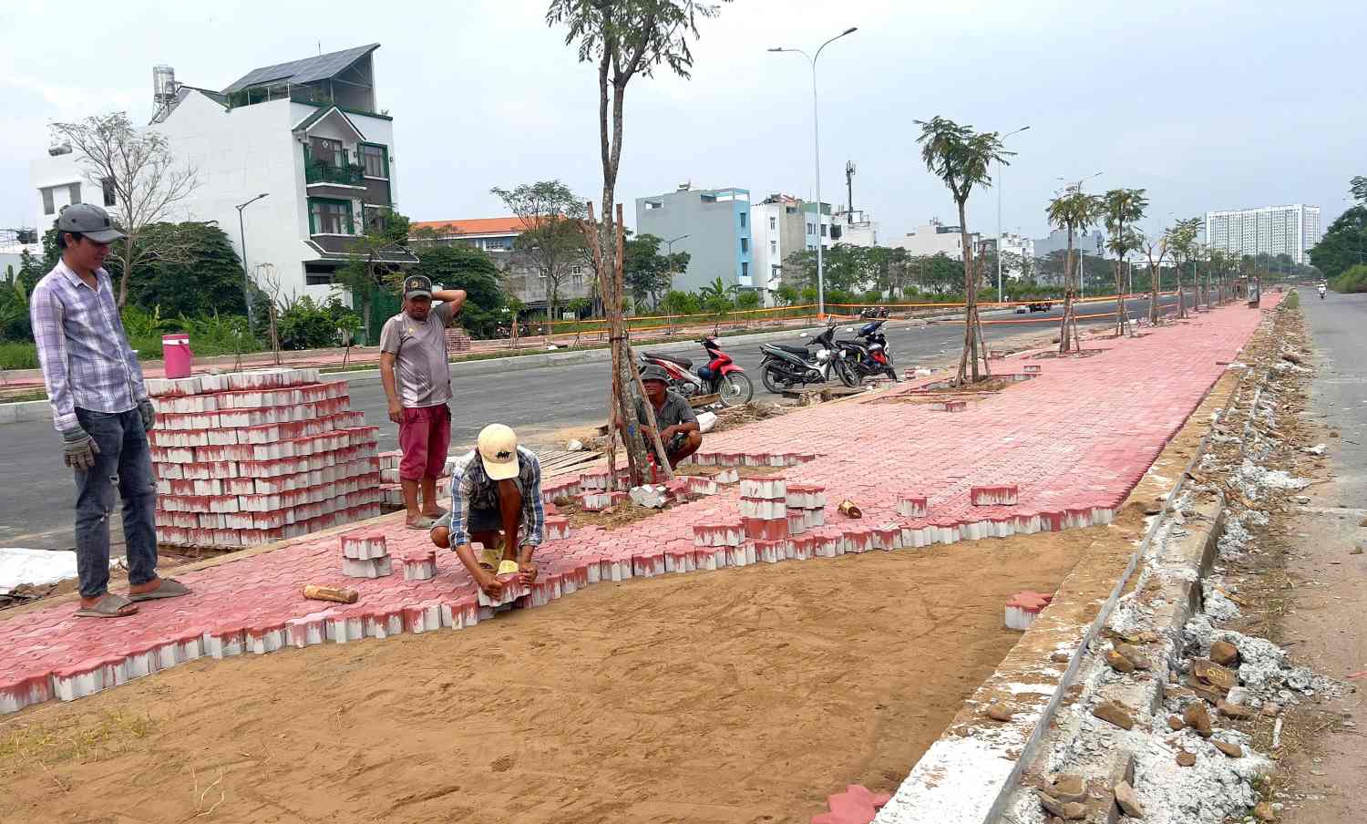 Cong nhan dang hoi ha thi cong, rai nhua duong doan giap tuyen Trinh Quang Nghi den nut giao quoc lo 50 hien huu.  Anh: Minh Quan