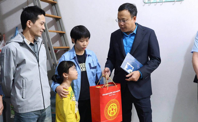 Ms. Hien and her husband and their young child (who had just been brought to Hanoi to visit) were surprised and happy to receive Tet gifts for workers from the Trade Union early. Photo: Manh Quan