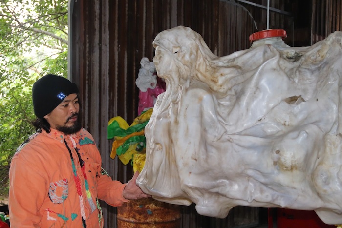 Painter Nguyen Quoc Dan with his artworks in Hoi An. Photo: Nguyen Linh