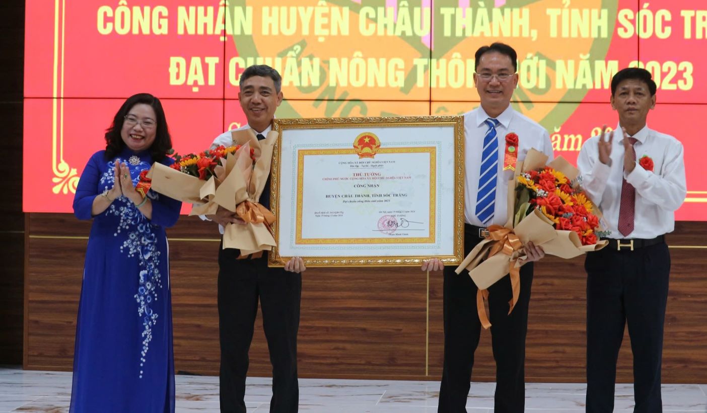 Ong Lam Van Man - Uy vien Trung uong Dang, Bi thu Tinh uy, Truong doan DBQH (bia phai) va ba Ho Thi Cam Dao - Pho bi Thu thuong truc Tinh uy, Chu tich HDND tinh Soc Trang trao quyet dinh cho huyen Chau Thanh. Anh: Phuong Anh