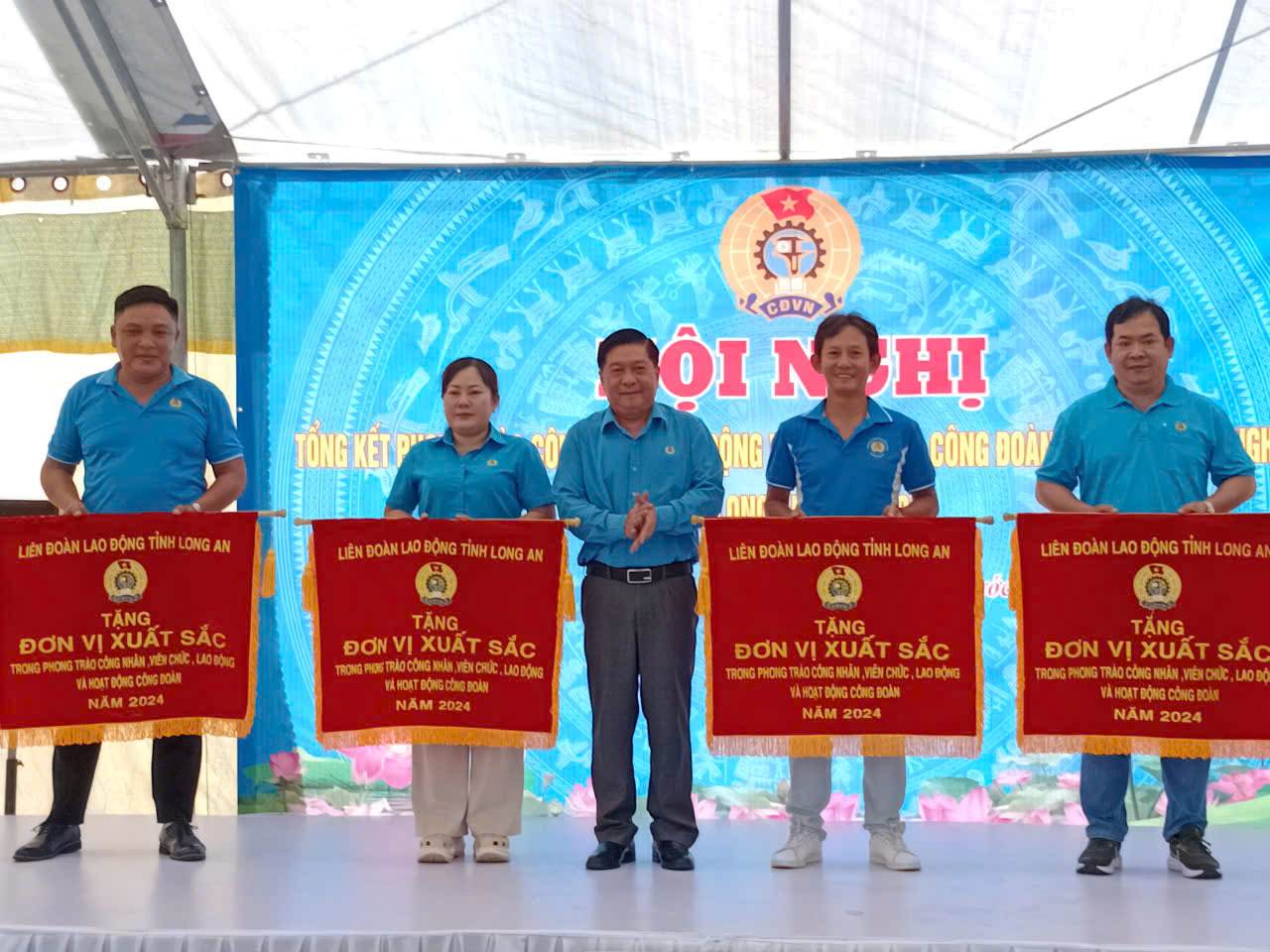 Chairman of Long An Provincial Labor Federation awarded emulation flags to outstanding units. Photo: Ky Quan