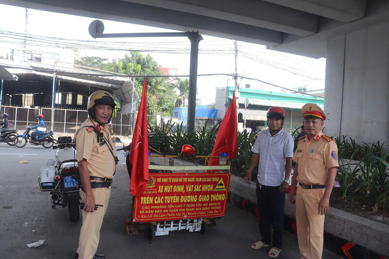 HCMC Traffic Police cooperate with people to collect nails. Photo: Huan Cao
