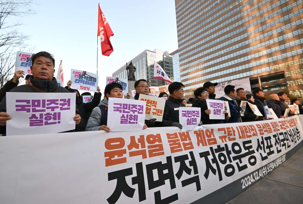 Nguoi bieu tinh Han Quoc giuong cao bieu ngu “chung toi len an lenh thiet quan luat bat hop phap cua ong Yoon Suk Yeol” tai Seoul ngay 4.12.2024. Anh: AFP