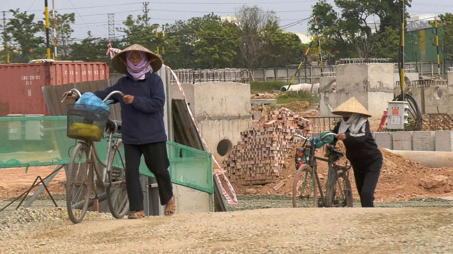 Con đường tạm qua công trình ngổn ngang gạch đá, nền là đá dăm gây khó khăn cho việc đi lại của người dân.