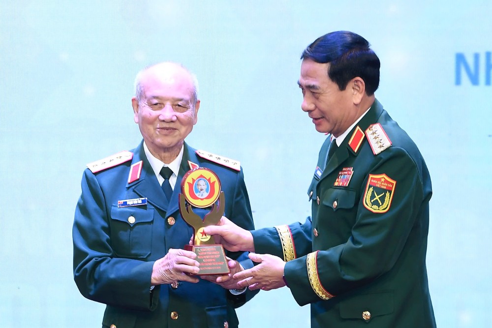 General Phan Van Giang - Minister of National Defense (right) - presents a symbol to honor the character in the work that won the Special Prize of the Writing Contest. Photo: T.Vuong