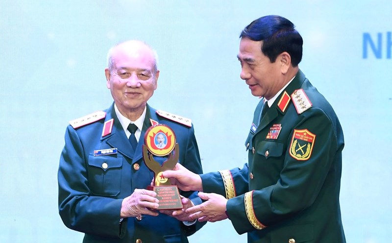 General Phan Van Giang - Minister of National Defense (right) - presents a symbol to honor the character in the work that won the Special Prize of the Writing Contest. Photo: T.Vuong