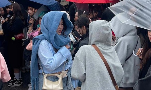 Khán giả đội mũ, che ô khi thời tiết Hà Nội mưa lạnh trước thềm concert "Anh trai say hi". Ảnh: Hoàng Huê