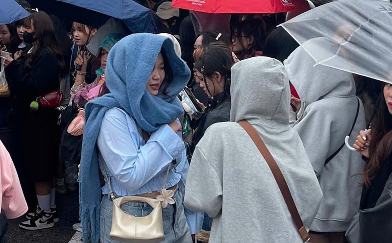 Audience members wear hats and hold umbrellas in the cold and rainy weather in Hanoi before the concert "Anh trai say hi". Photo: Hoang Hue