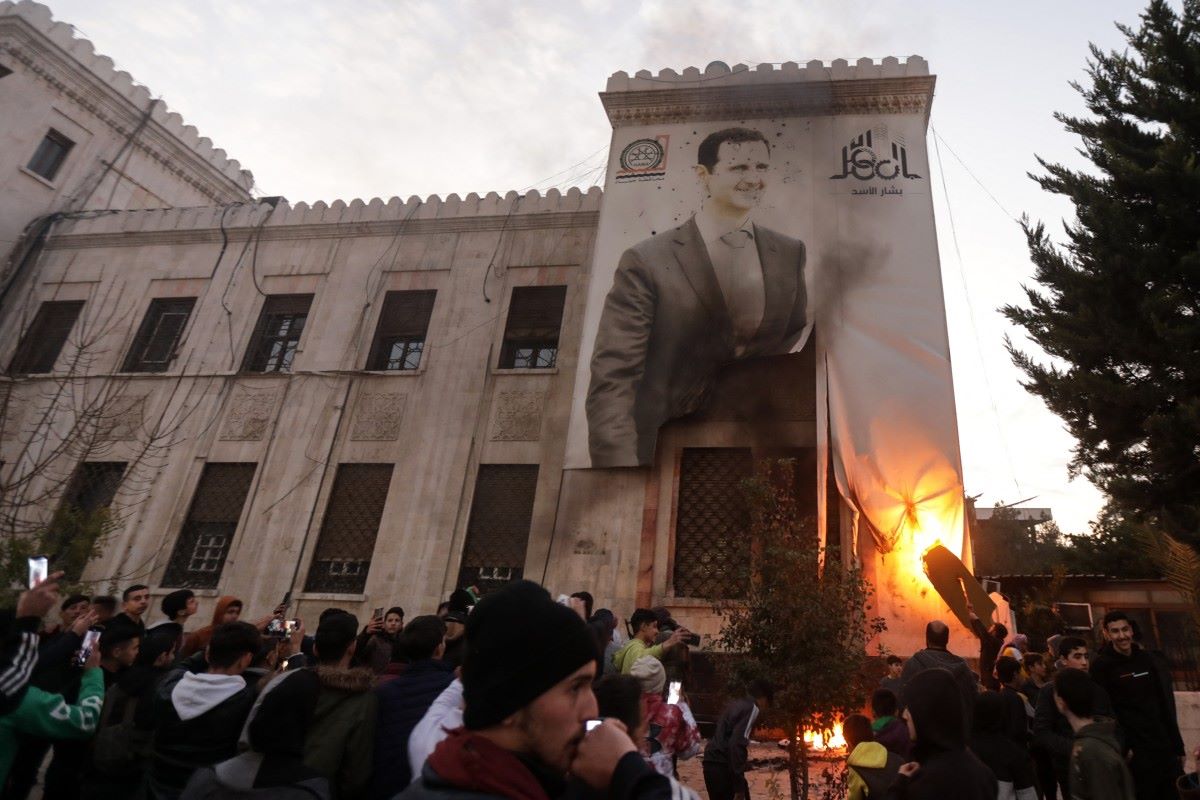 People in Hama burned large banners with Syrian President Bashar al-Assad on 5.12.2024. Photo: AFP
