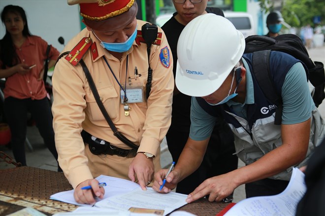 Traffic police draw up a record of administrative violations. Photo: Pham Dong