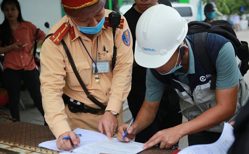 Traffic police draw up a record of administrative violations. Photo: Pham Dong