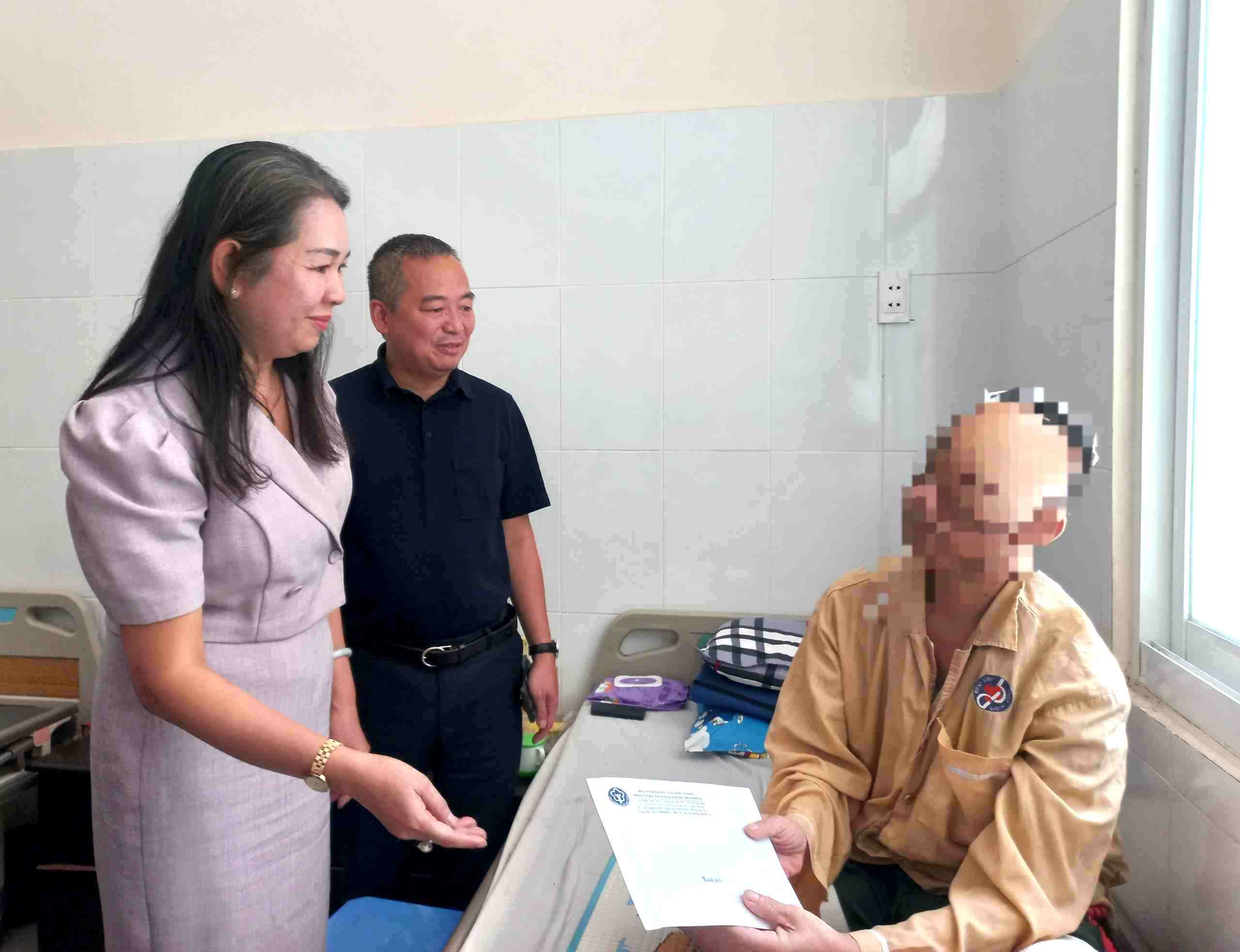 Bà Lê Minh Lý - Giám đốc BHXH Bình Dương tặng quà cho bệnh nhân nghèo điều trị nội trú tại Bệnh viện Đa khoa tỉnh Bình Dương. Ảnh: Đình Trọng