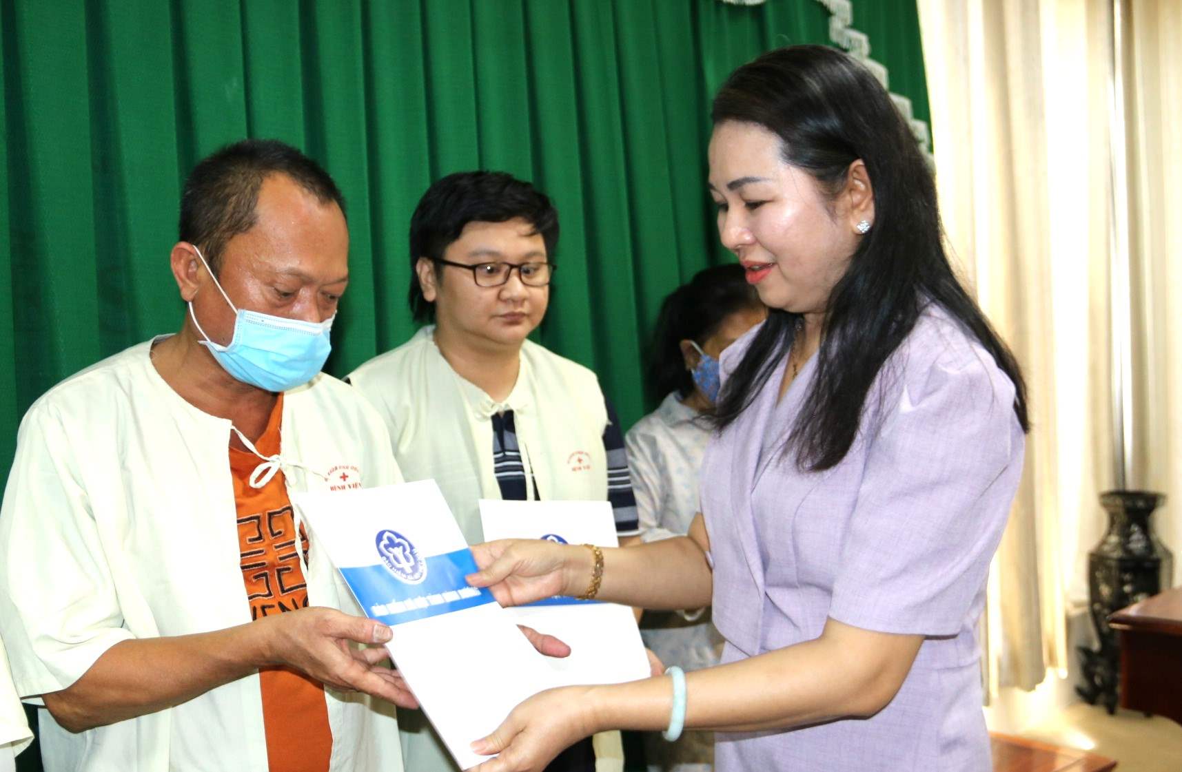 Bà Lê Minh Lý - Giám đốc BHXH Bình Dương tặng quà cho bệnh nhân nghèo điều trị nội trú tại Bệnh viện Đa khoa tỉnh Bình Dương. Ảnh: Đình Trọng