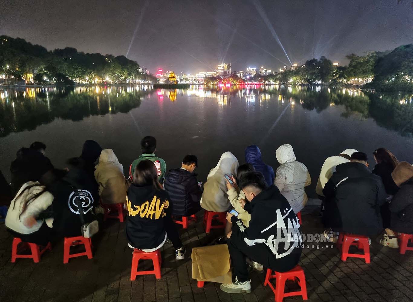 Người dân tìm cho mình chỗ ngồi đẹp nhất quanh khu vực Hồ Gươm để ngắm pháo hoa. Một số người dân đã mang ghế nhựa ra cho thuê với giá khoảng 50.000 đồng/ghế.