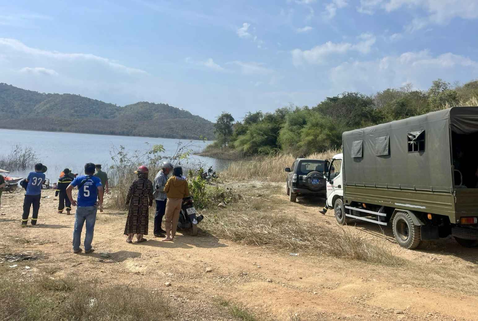 Lực lượng chức năng và người dân địa phương triển khai tìm kiếm tại hồ Sông Móng. Ảnh: Duy Tuấn 