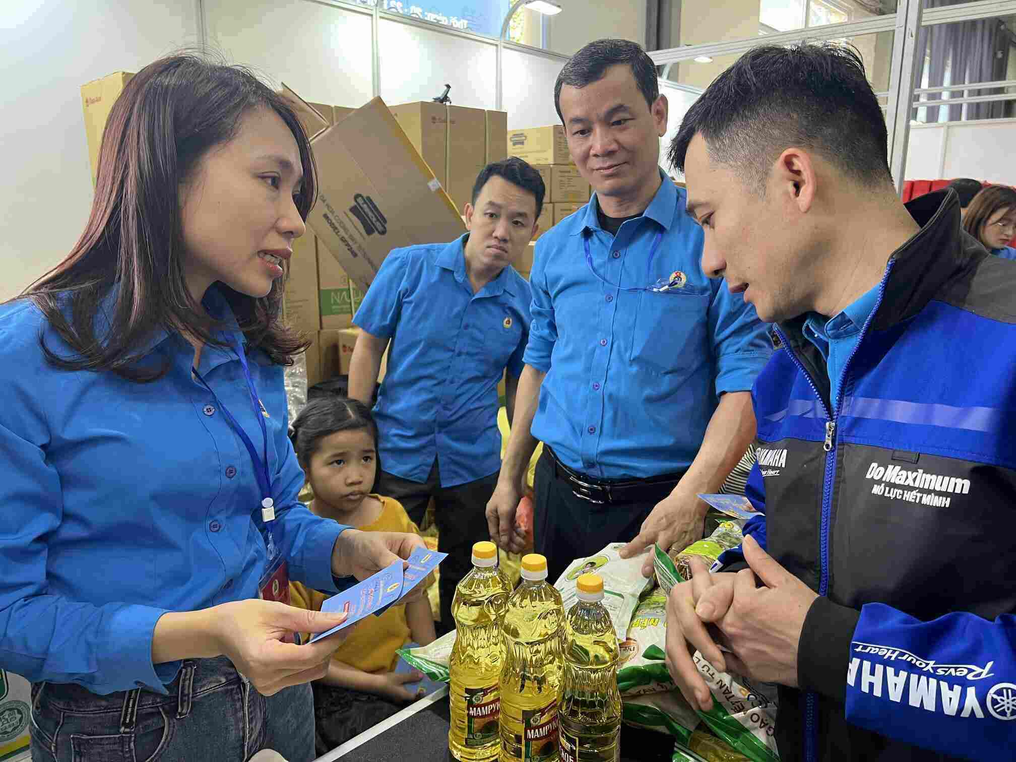 Cán bộ Công đoàn Hà Nội hướng dẫn đoàn viên, người lao động sử dụng phiếu mua hàng 0 đồng tại gian hàng 0 đồng ở Chợ Tết Công đoàn năm Giáp Thìn. Ảnh: Kiều Vũ