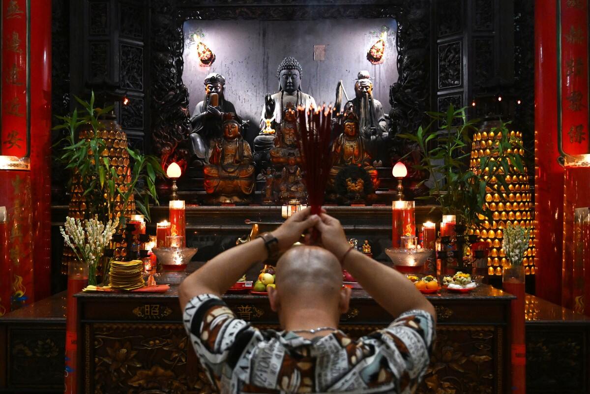 Một người đàn ông cầu nguyện tại chùa Satya Dharma ở Denpasar trên đảo Bali, Indonesia đêm giao thừa Tết Nguyên đán Giáp Thìn. Ảnh: AFP