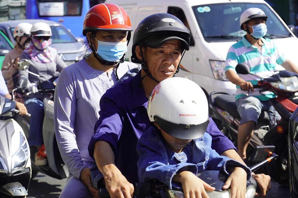 Nhiều gia đình có con nhỏ phải vất vả di chuyển giữa thời tiết nắng nóng trưa mùng 2 Tết.