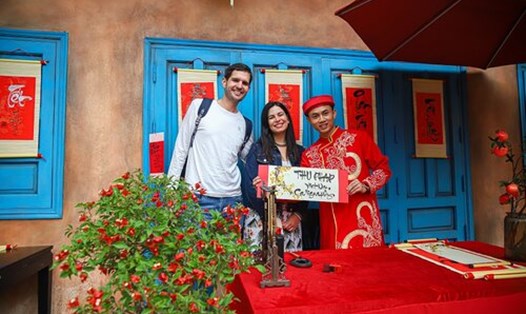 Du khách nước ngoài hào hứng trải nghiệm những hoạt động dịp Tết Nguyên đán. Ảnh: H. Hà