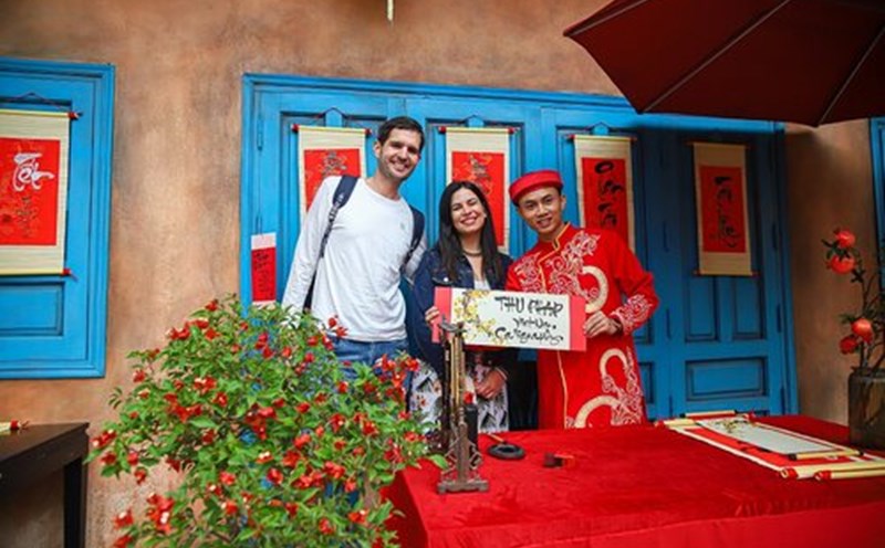 Du khách nước ngoài hào hứng trải nghiệm những hoạt động dịp Tết Nguyên đán. Ảnh: H. Hà