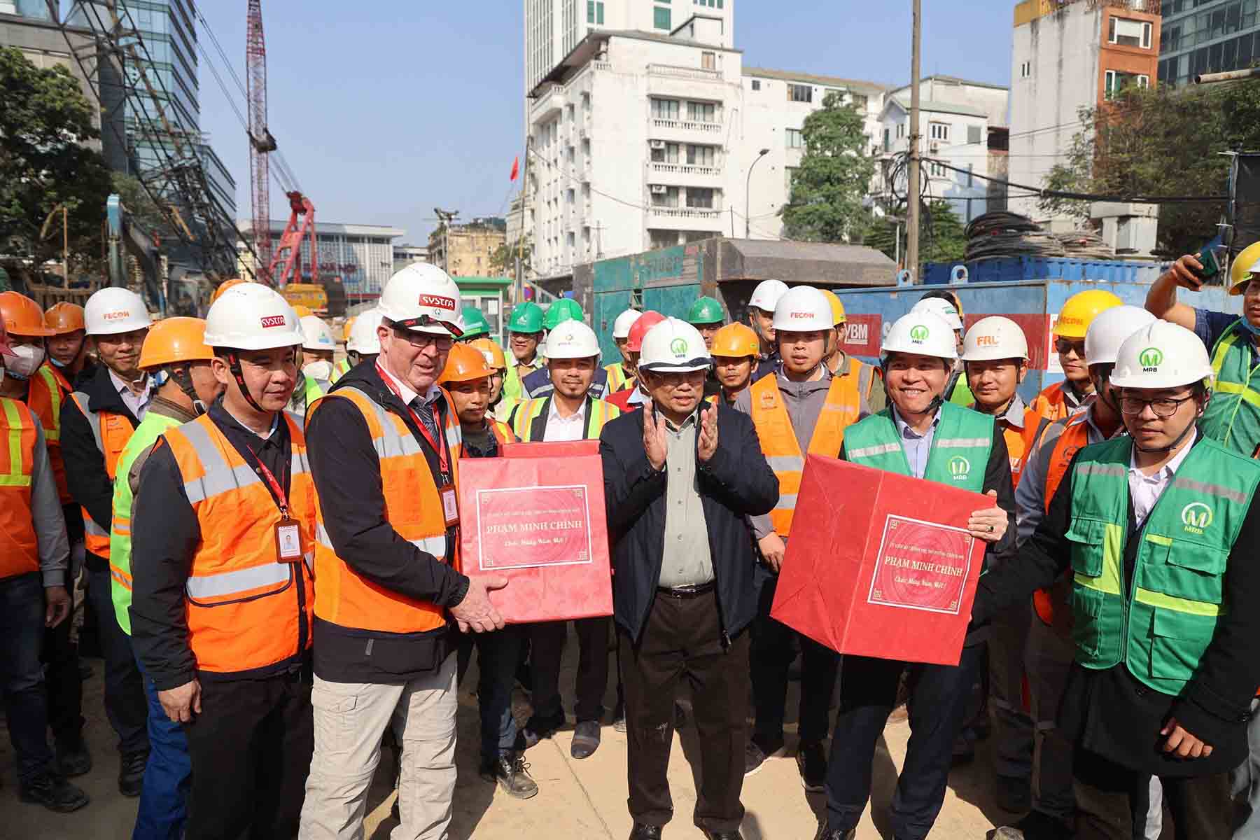 Thủ tướng Chính phủ Phạm Minh Chính tặng quà công nhân công trường đường sắt đô thị. Ảnh: Phạm Đông 