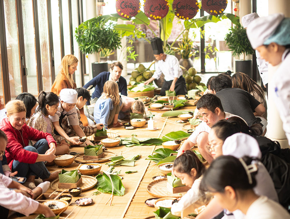 Du khách trải nghiệm gói bánh chưng Tết tại Banyan Tree Lăng Cô, Thừa Thiên Huế. Ảnh: NVCC