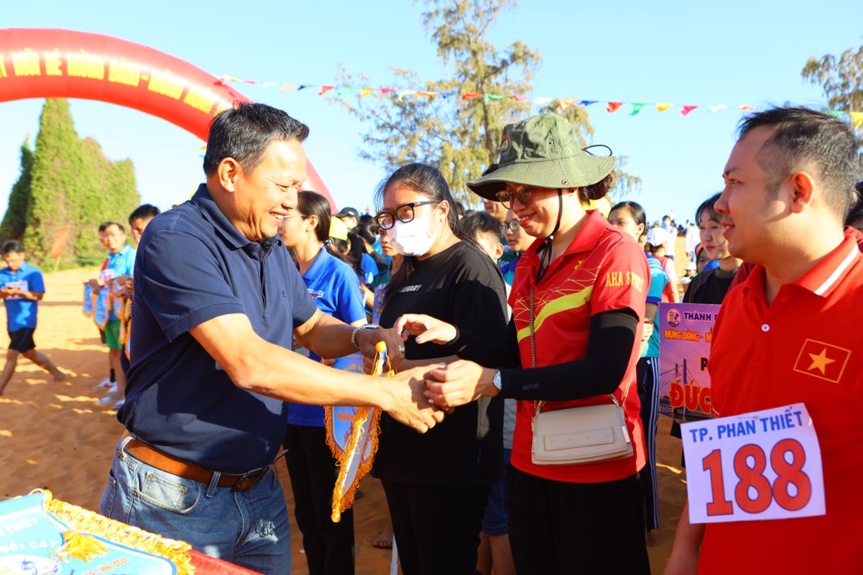 Ông Phạm Văn Nam - Bí thư Thành uỷ TP Phan Thiết tặng cờ lưu niệm cho các đoàn vận động viên. Ảnh: Duy Tuấn 