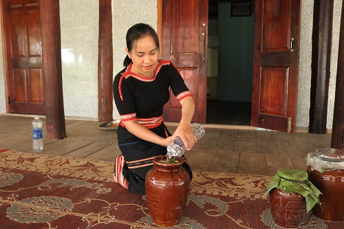 Con gái ở làng Chốt đổ nước lọc vào bình rượu cần để phục vụ ngày lễ tết. Ảnh: Thanh Tuấn 