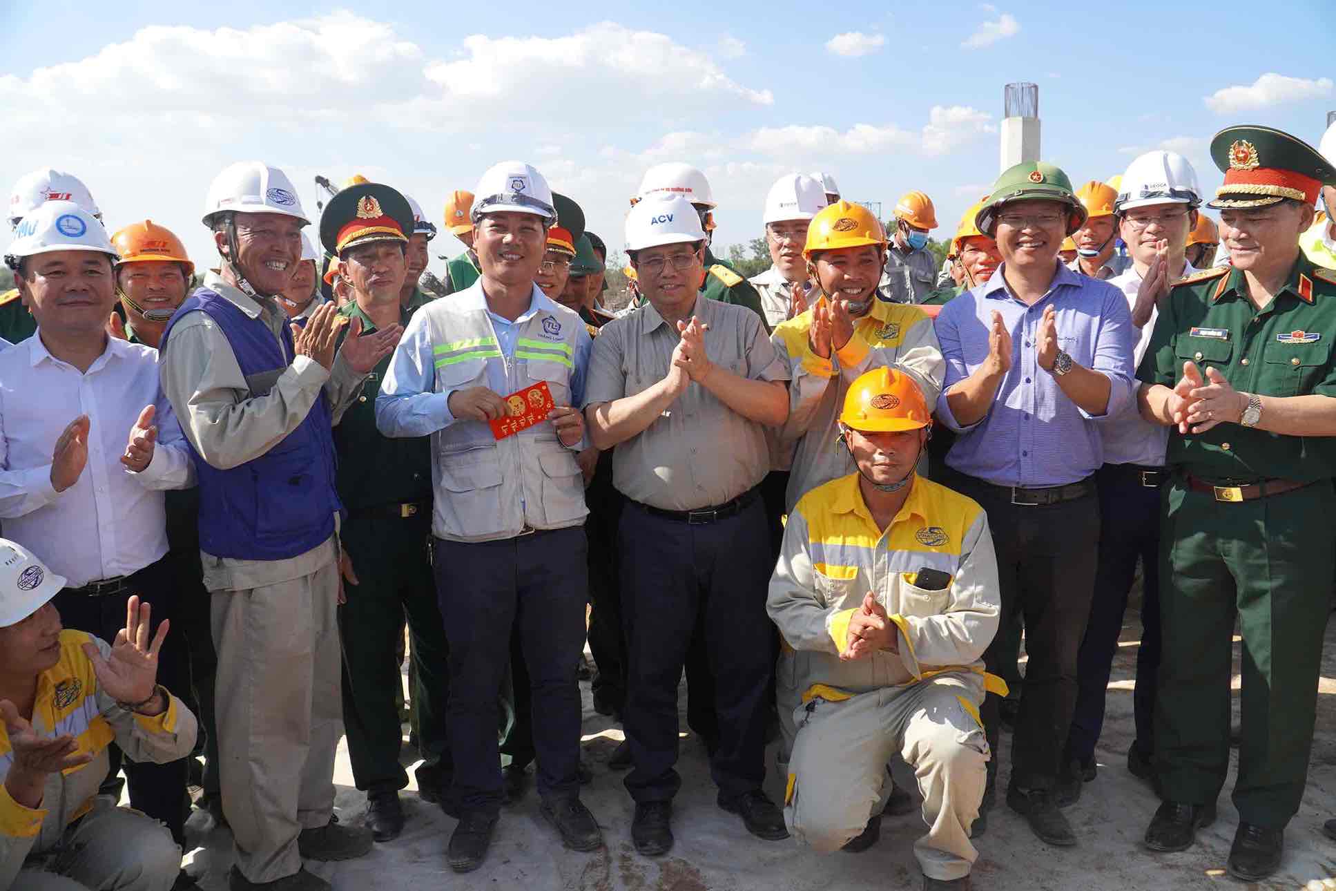 Thủ tướng Phạm Minh Chính chụp hình chung với các cán bộ, kỹ sư, công nhân lao động đang thi công xuyên Tết trên cao tốc Biên Hoà - Vũng Tàu đoạn qua tỉnh Đồng Nai. Ảnh: Hà Anh Chiến