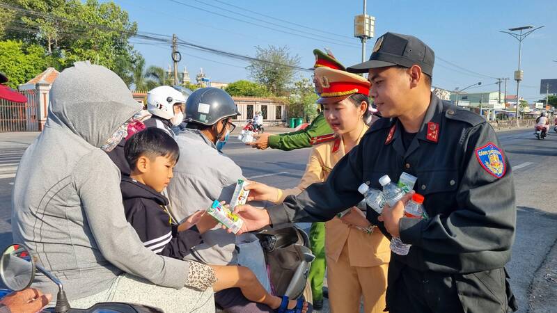 Lực lượng Công an tỉnh Vĩnh Long tổ chức phát gần 5.000 chai nước suối, sữa tươi đến người đi đường. Ảnh: Hoàng Lộc