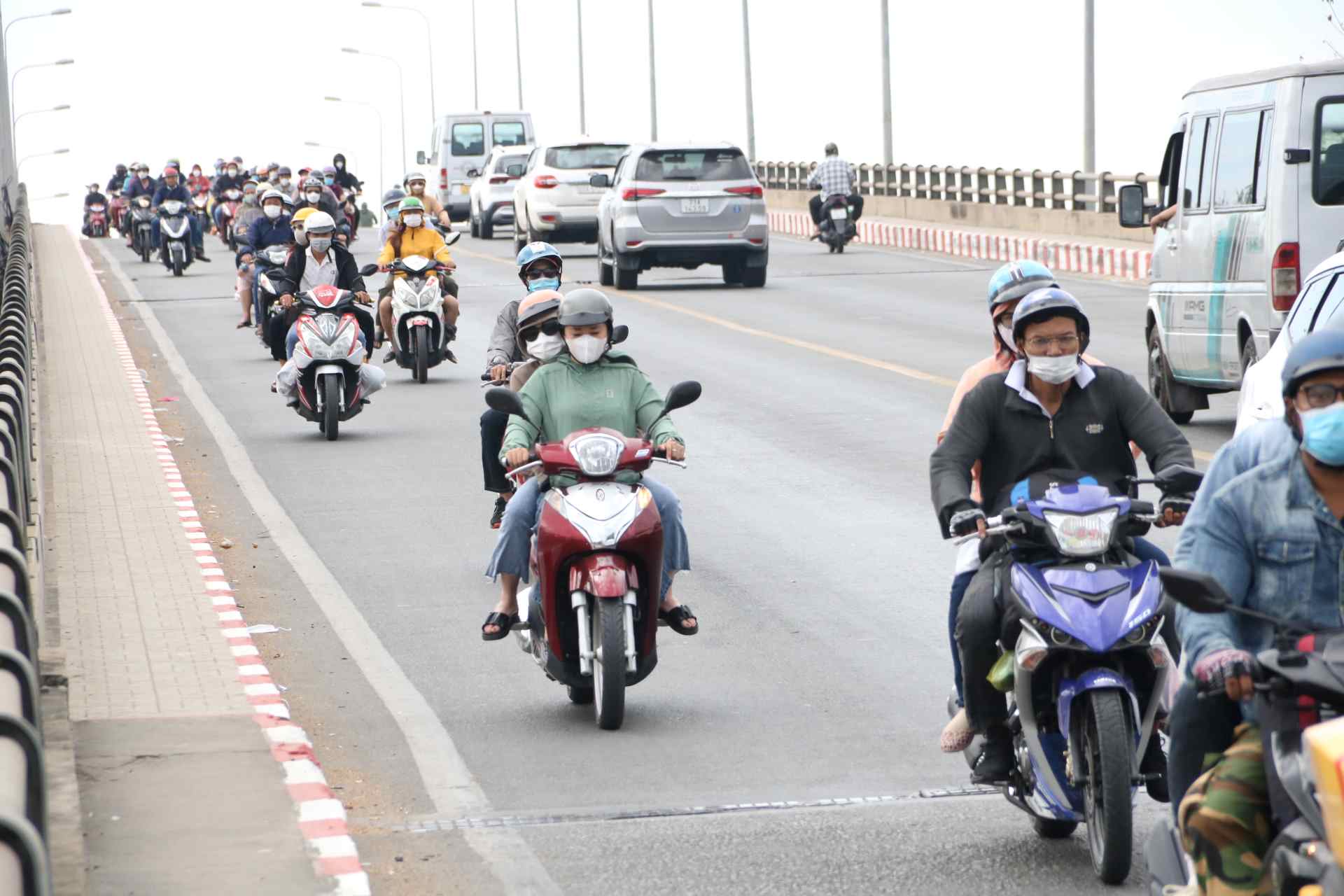 Dòng xe máy từ huyện Củ Chi, TPHCM đi qua thành phố Thủ Dầu Một, Bình Dương mỗi lúc một đông hơn.