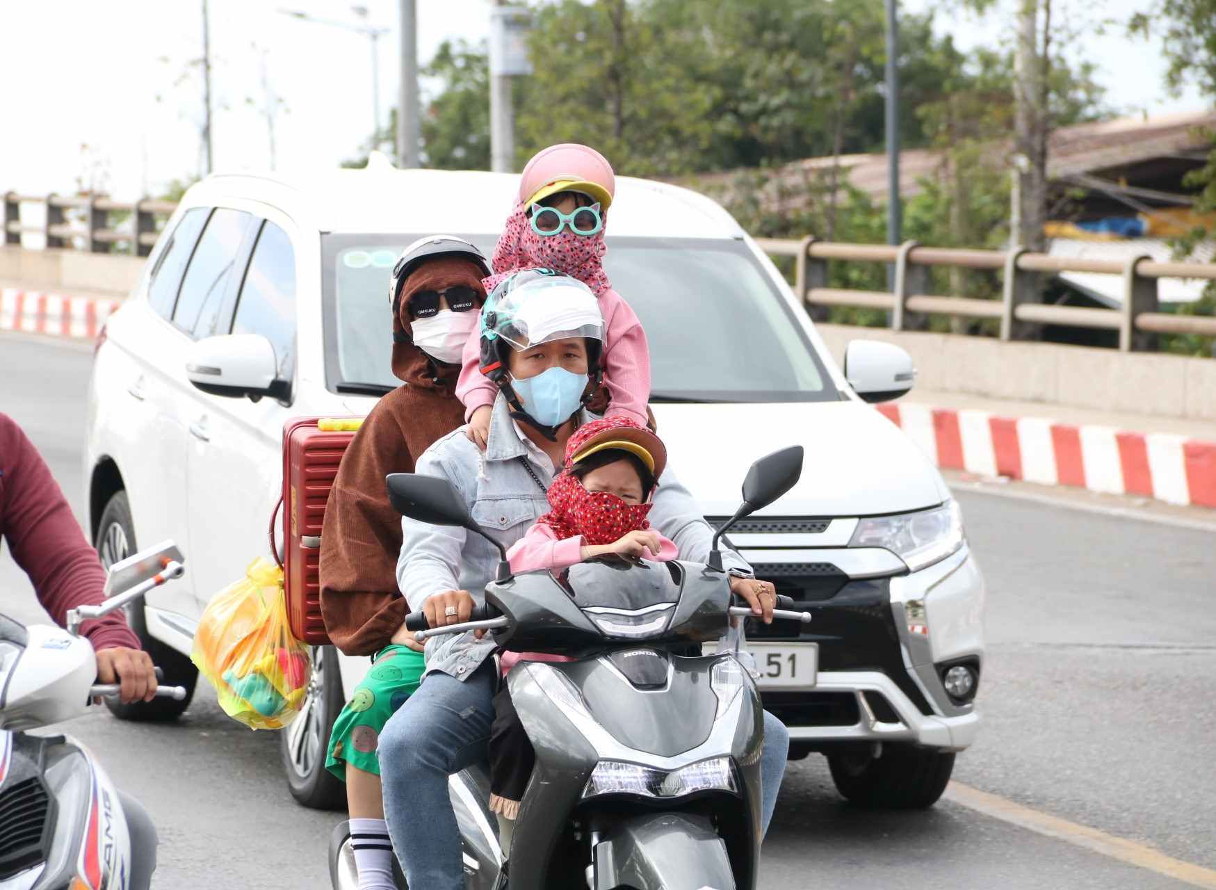 Dù đi xe máy quãng đường xa, người lao động vẫn chở theo con cái và nhiều đồ đạc.