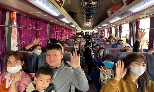 Công nhân Nghệ An vui mừng trên chuyến xe công đoàn trở lại thủ đô Hà Nội vào ngày mùng 5 Tết Nguyên đán. Ảnh: Quang Đại