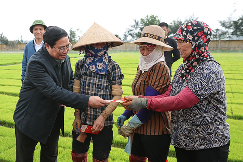 Thủ tướng Chính phủ Phạm Minh Chính lì xì đầu năm cho nông dân. Ảnh: Nhật Bắc