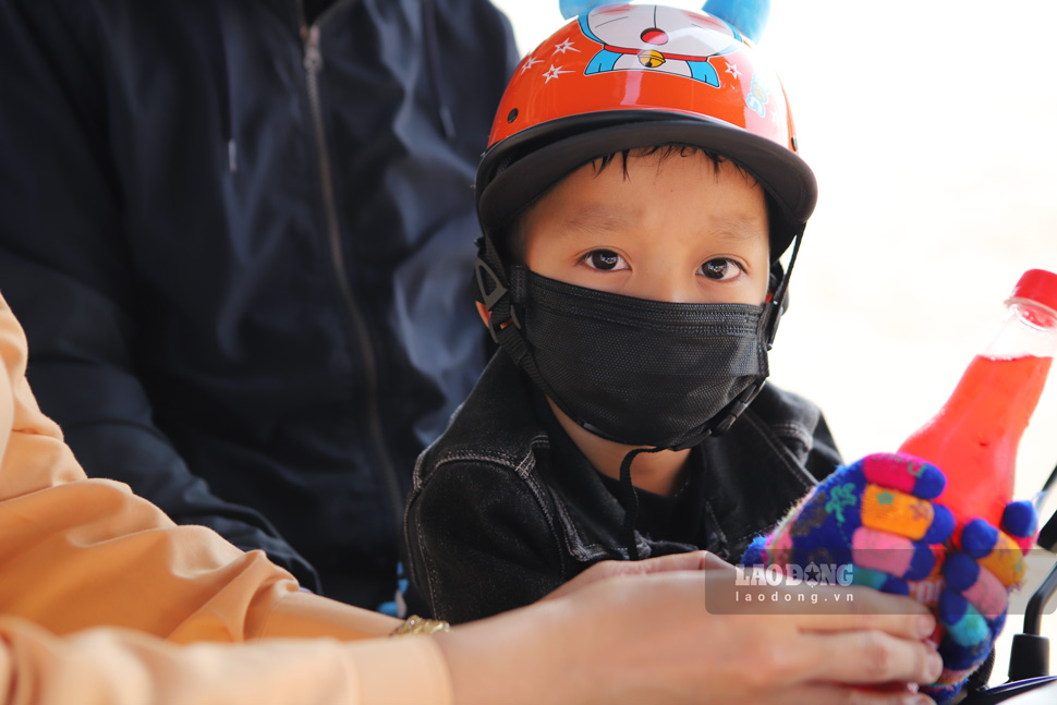 Nhiều bạn nhỏ theo bố mẹ trở lại TP Hồ Chí Minh bằng xe máy sau thời gian về đón Tết bên ông bà. Ảnh: Hoài Luân