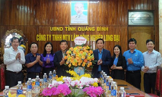 Chủ tịch LĐLĐ tỉnh Quảng Bình Phạm Tiến Nam tặng hoa, chúc Công ty TNHH MTV Lâm công nghiệp Long Đại.  Ảnh: Lê Phi Long