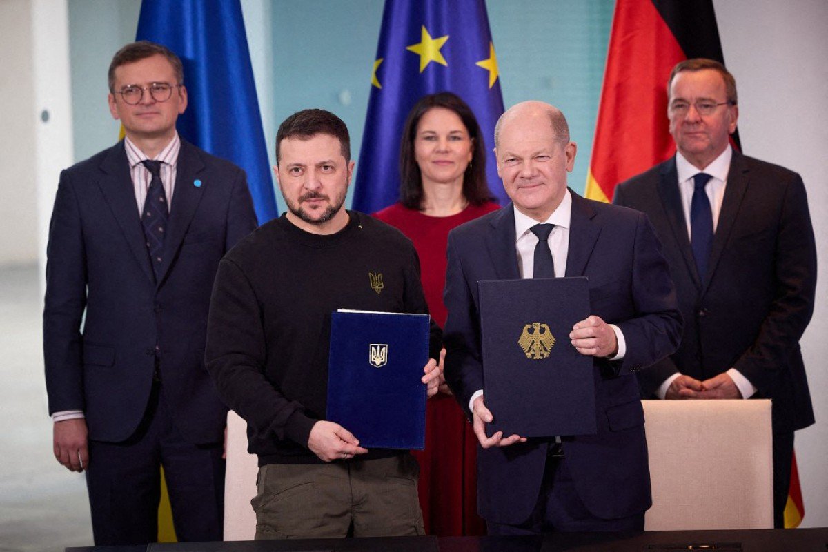 Tổng thống Ukraina Volodymyr Zelensky (trái, hàng đầu) trao đổi thỏa thuận an ninh với Thủ tướng Đức Olaf Scholz (phải, hàng đầu), ngày 16.2.2024. Ảnh: AFP