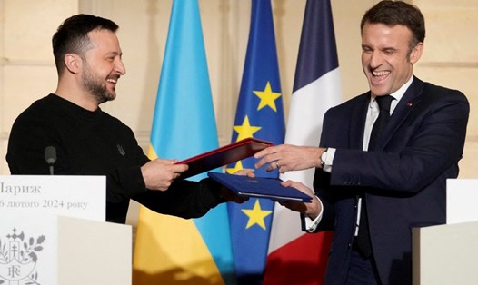Tổng thống Ukraina Volodymyr Zelensky (trái) trao đổi thỏa thuận an ninh với Tổng thống Pháp Emmanuel Macron, ngày 16.2.2024. Ảnh: AFP