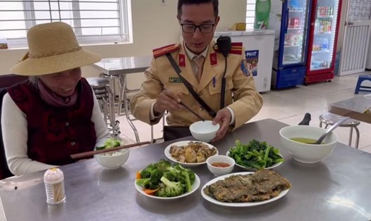 Cụ Mai Thị Đông dùng bữa cơm cùng cán bộ, chiến sĩ tại Đội Cảnh sát giao thông số 4 (Hà Nội). Ảnh: Công an cung cấp
