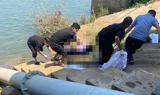 Lực lượng chức năng đưa thi thể người phụ nữ lên bờ sông Đồng Nai. Ảnh: CTV