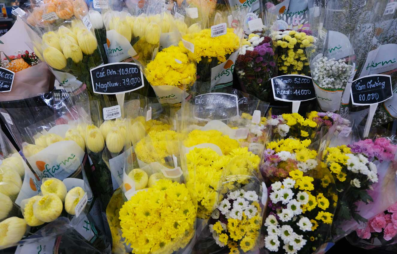 Tại siêu thị, các loại hoa tươi cũng được trưng bày đa dạng và bán với giá rẻ hơn ngày Tết.
