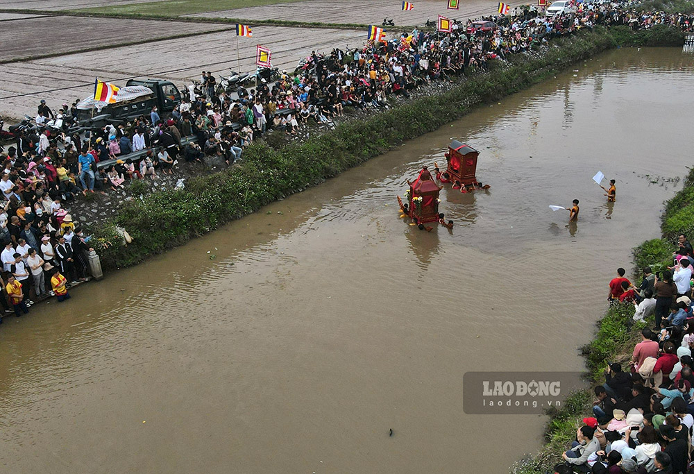 Đoàn rước kiệu lội sông trước cổng chùa Phượng Vũ.