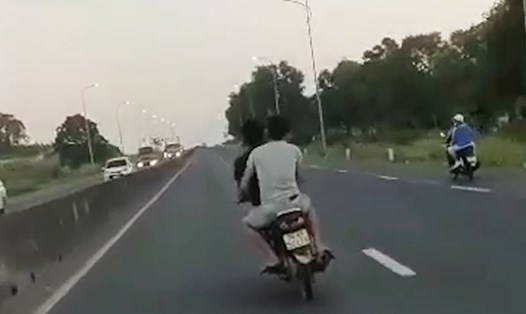 Hai thanh niên ở Phú Yên đầu trần lái xe máy, lạng lách trước ôtô trên QL1. Ảnh cắt từ clip