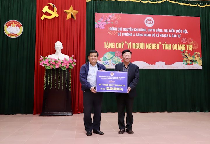 Bộ trưởng Nguyễn Chí Dũng tặng “Quỹ vì người nghèo” của tỉnh Quảng Trị 100 triệu đồng. Ảnh: MPI  