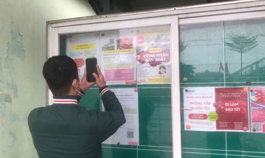 Người lao động tìm kiếm thông tin tuyển dụng tại bảng tuyển dụng trước cổng Khu công nghiệp Thăng Long (Hà Nội). Ảnh: Phương Hân