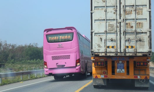 Ôtô khách vượt qua chiếc xe container trên cao tốc Cam Lộ - La Sơn. Ảnh: Hưng Thơ