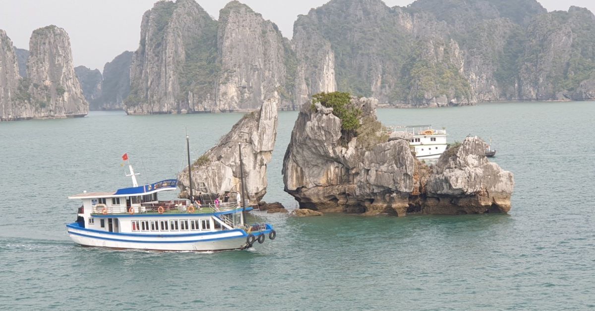 Hai chiếc tàu du lịch đi sát vào chân hòn Trống Mái. Ảnh: Nguyễn Hùng